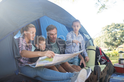 Family reading the map in tent