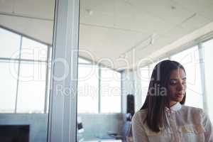 Thoughtful businesswoman standing in office