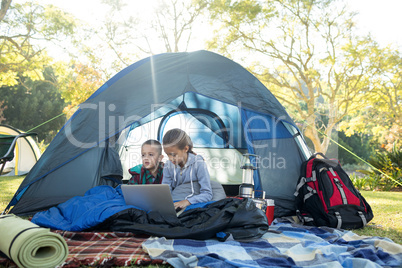 Kids using laptop in the tent