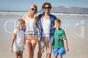 Portrait of happy family standing together at beach