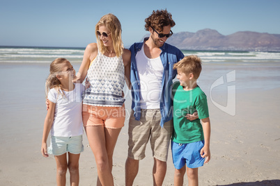 Happy family standing together at beach