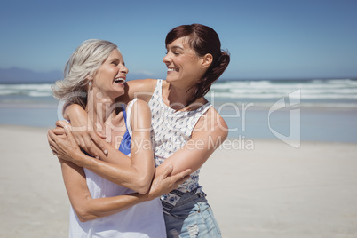 Happy woman with her mother standing at beach