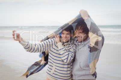 Happy young couple taking selfie during winter