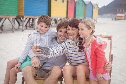 Smiling family taking selfie at beach