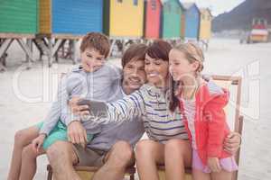 Smiling family taking selfie at beach