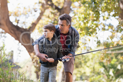 Father and son fishing in forest