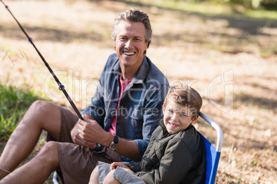 Cheerful father and son fishing on sunny day