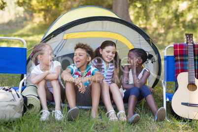 Happy friends sitting in tent