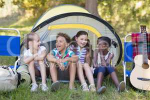 Happy friends sitting in tent