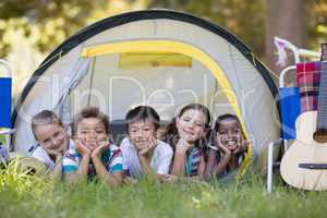 Smiling friends resting in tent at campsite