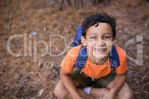 High angle portrait of boy sitting in forest
