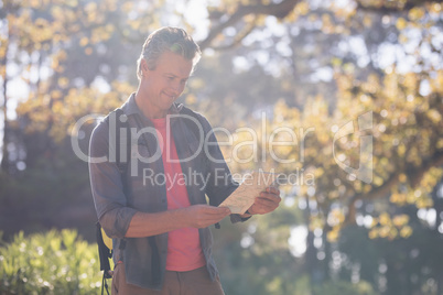 Mature man reading map in forest