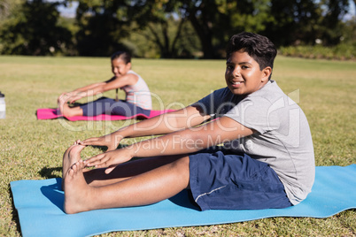 Portrait of boy touching toes during yoga glass