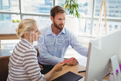 Attentive executives working over personal computer at desk
