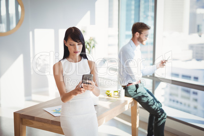 Attentive executives using mobile phone at desk