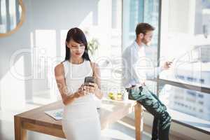 Attentive executives using mobile phone at desk