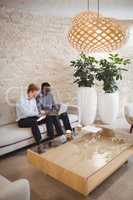 Attentive executives using digital tablet and laptop