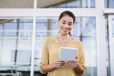 Smiling businesswoman using tablet in office