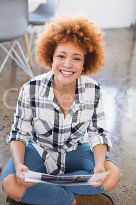 Portrait of smiling businesswoman sitting at creative office