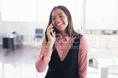 Smiling creative businesswoman talking on mobile phone