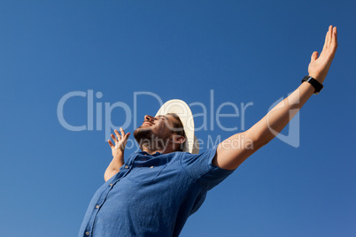 Man standing at beach with arms outstretched