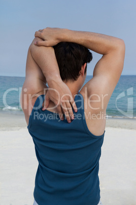 Man stretching his hand on beach