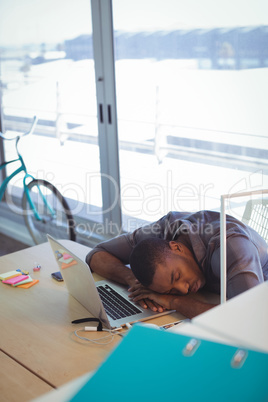 Tired businessman napping on desk in office