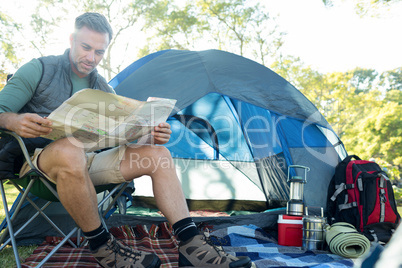 Man reading the map outside the tent