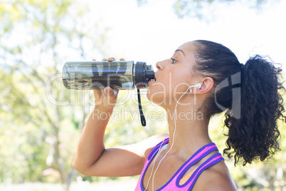 Close-up of female jogger drinking water