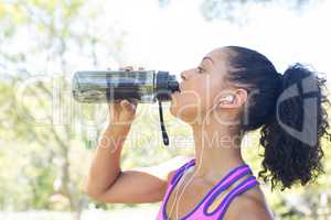 Close-up of female jogger drinking water