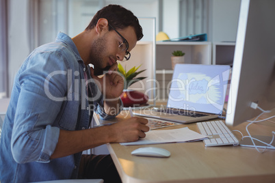 Businessman talking on phone while working at creative office