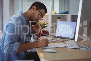 Businessman talking on phone while working at creative office