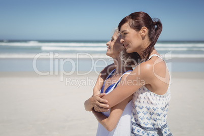 Side view of happy woman embracing her mother at beach