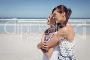 Side view of happy woman embracing her mother at beach