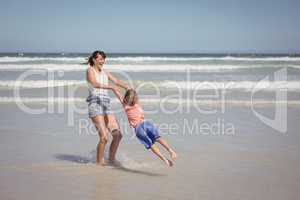 Happy mother enjoying with son on shore at beach