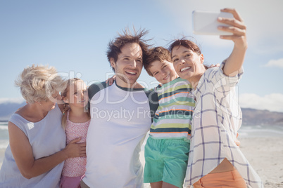 Happy multi-generation family taking selfie at beach