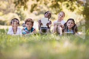 Portrait of friends using digital tablets at campsite