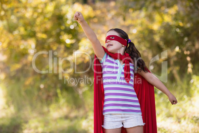 little girl trying to fly while wearing superhero costume