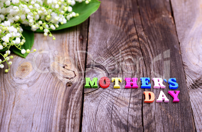 Gray wooden background with the inscription Mother's Day