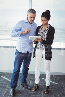 Executives discussing over digital tablet