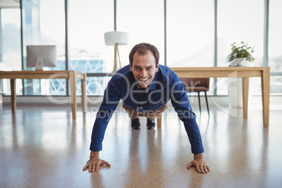 Portrait of smiling executive doing push-ups