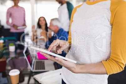Midsection of businesswoman using tablet pc