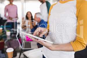 Midsection of businesswoman using tablet pc