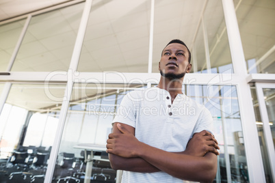 Low angle view of thoughtful businessman with arms crossed