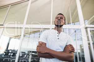 Low angle view of thoughtful businessman with arms crossed