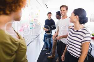 Smiling business people standing by whiteboard