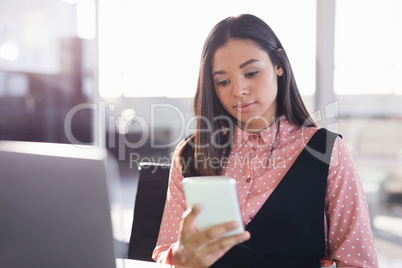 Thoughtful businesswoman using mobile phone