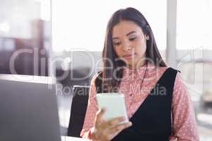 Thoughtful businesswoman using mobile phone