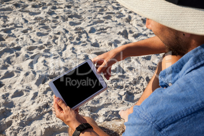 Man using digital tablet on the beach