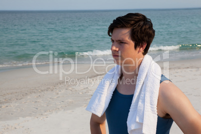 Thoughtful man standing with towel around his neck